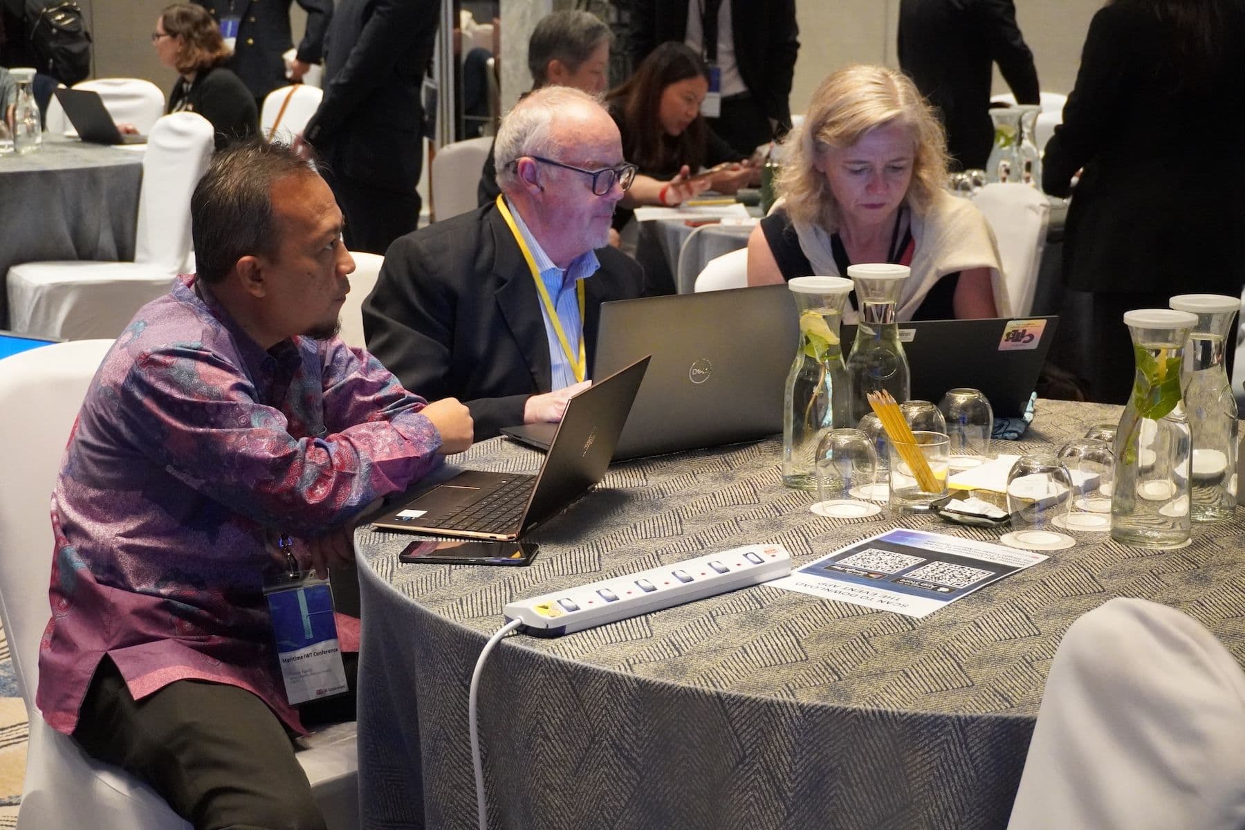 Conference participants collaborating around laptops during the Maritime IWT Conference.