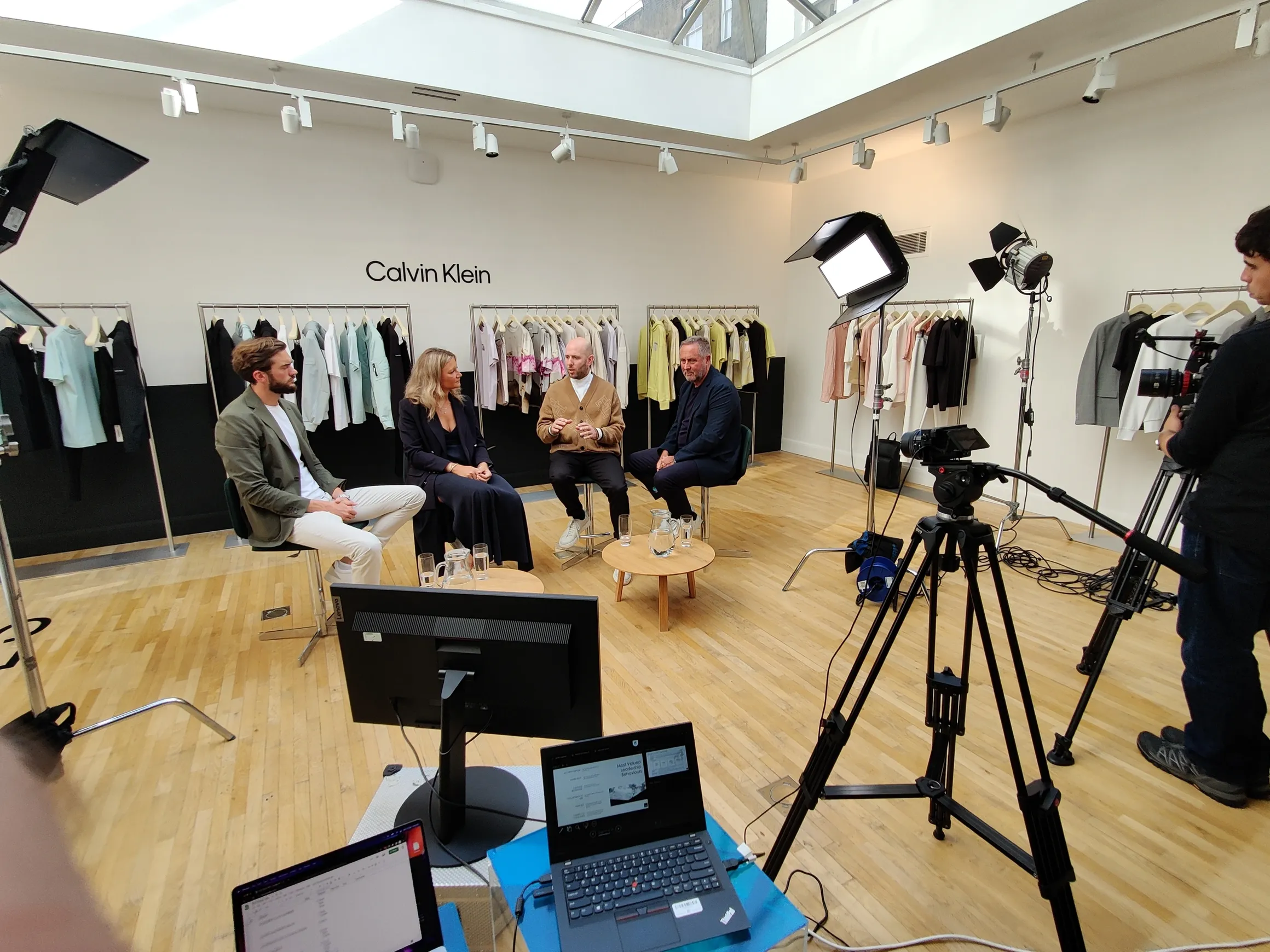 Multi-camera production setup filming a panel discussion in a branded environment.